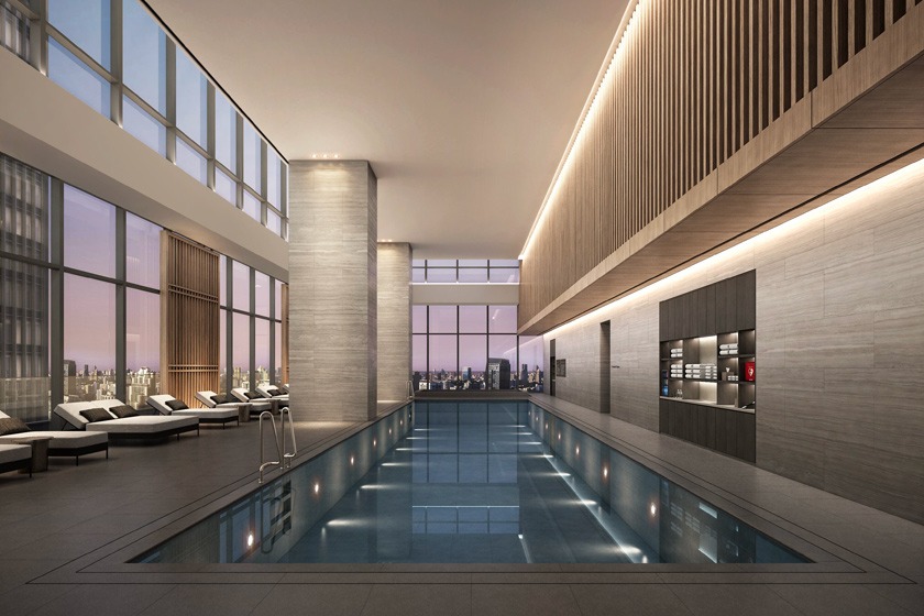 Indoor swimming pool at Shilla Monogram Hanoi Westlake with floor-to-ceiling windows looking out over the Hanoi skyline at dusk