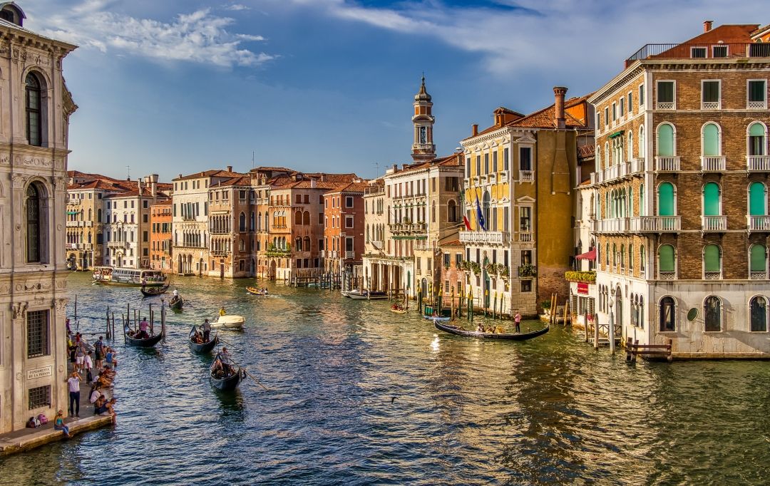 Gondolas on a Venice canal; Venice flight searches up 101% with fares down 22%